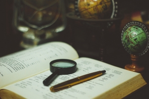 Photo by João Silas click pen and magnifying glass on book page