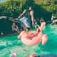 A dude diving into a pool at a party.