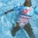 toddler wearing blue floral pool float on swimming pool