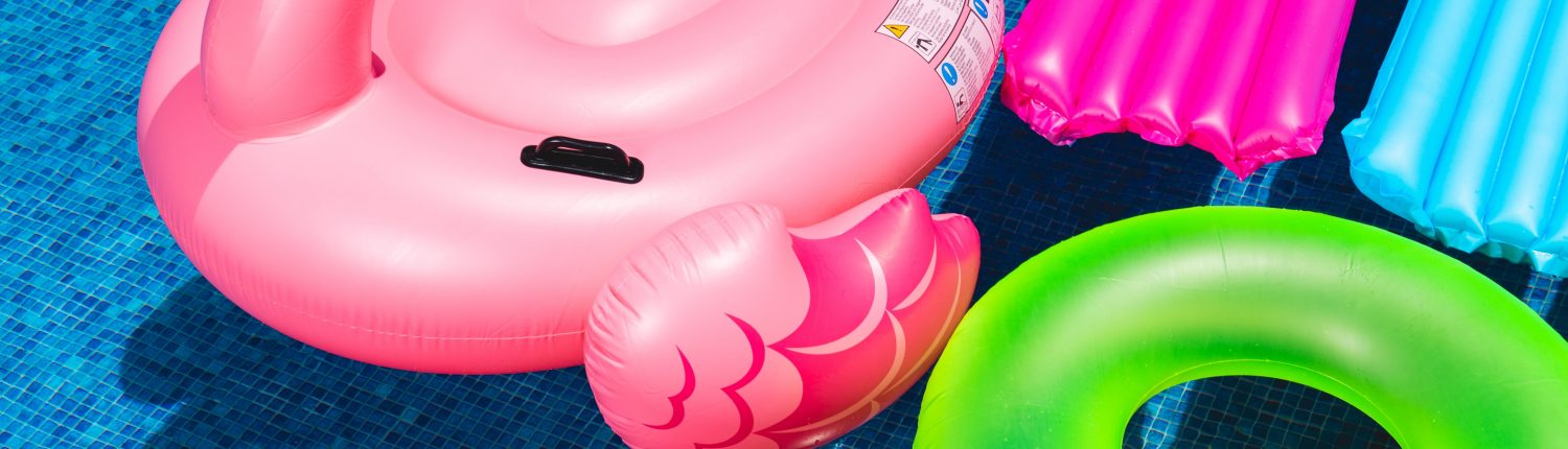 pink inflatable flamingo and green inflatable ring