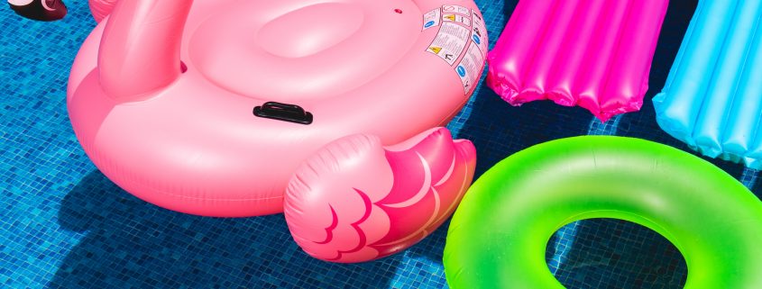 pink inflatable flamingo and green inflatable ring